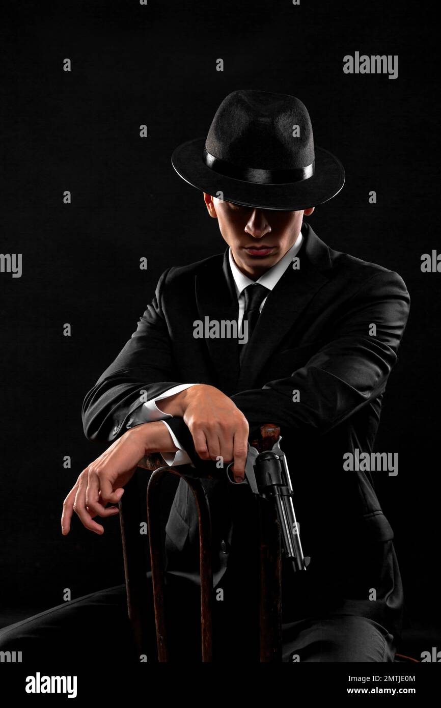 Vertical portrait of gangster from 1940s with a gun Man in a black Vertical portrait of gangster from 1940s with a gun Man in a black