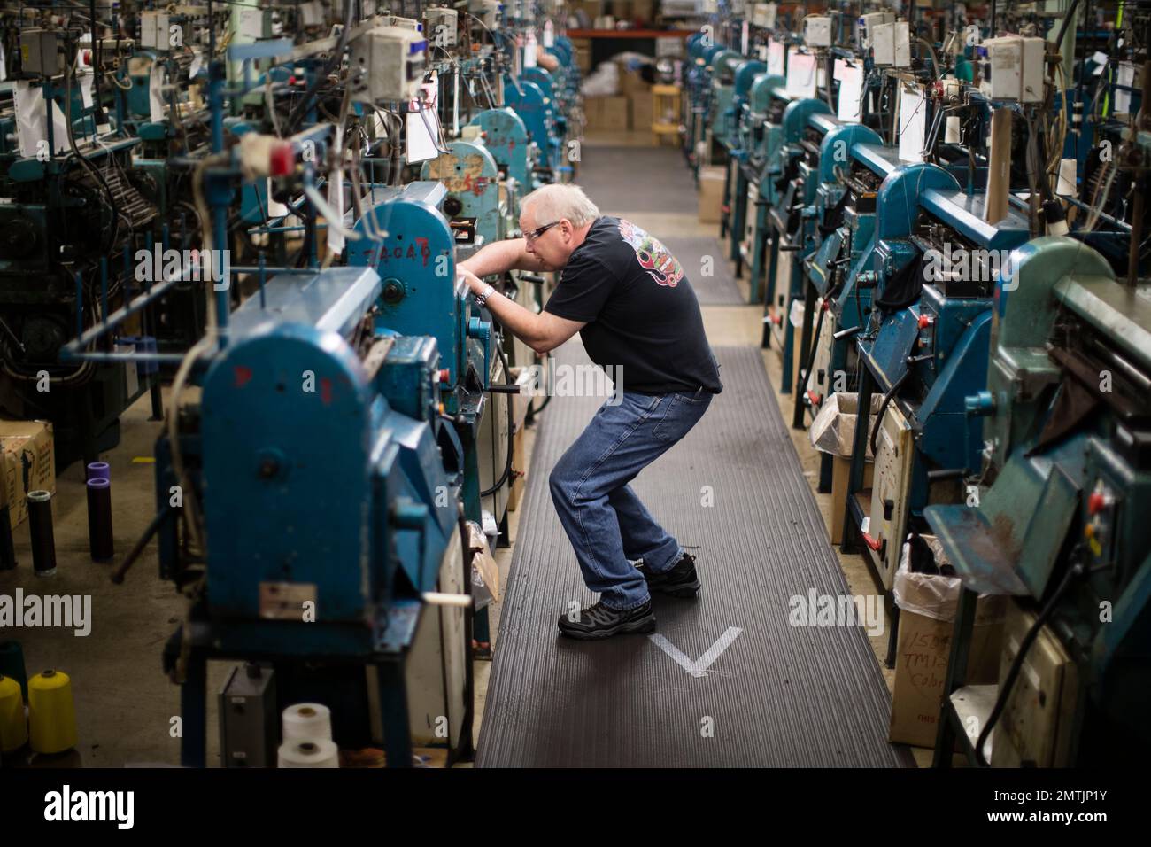 Jeff Geletka operates a knitting machine used in the manufacturing of