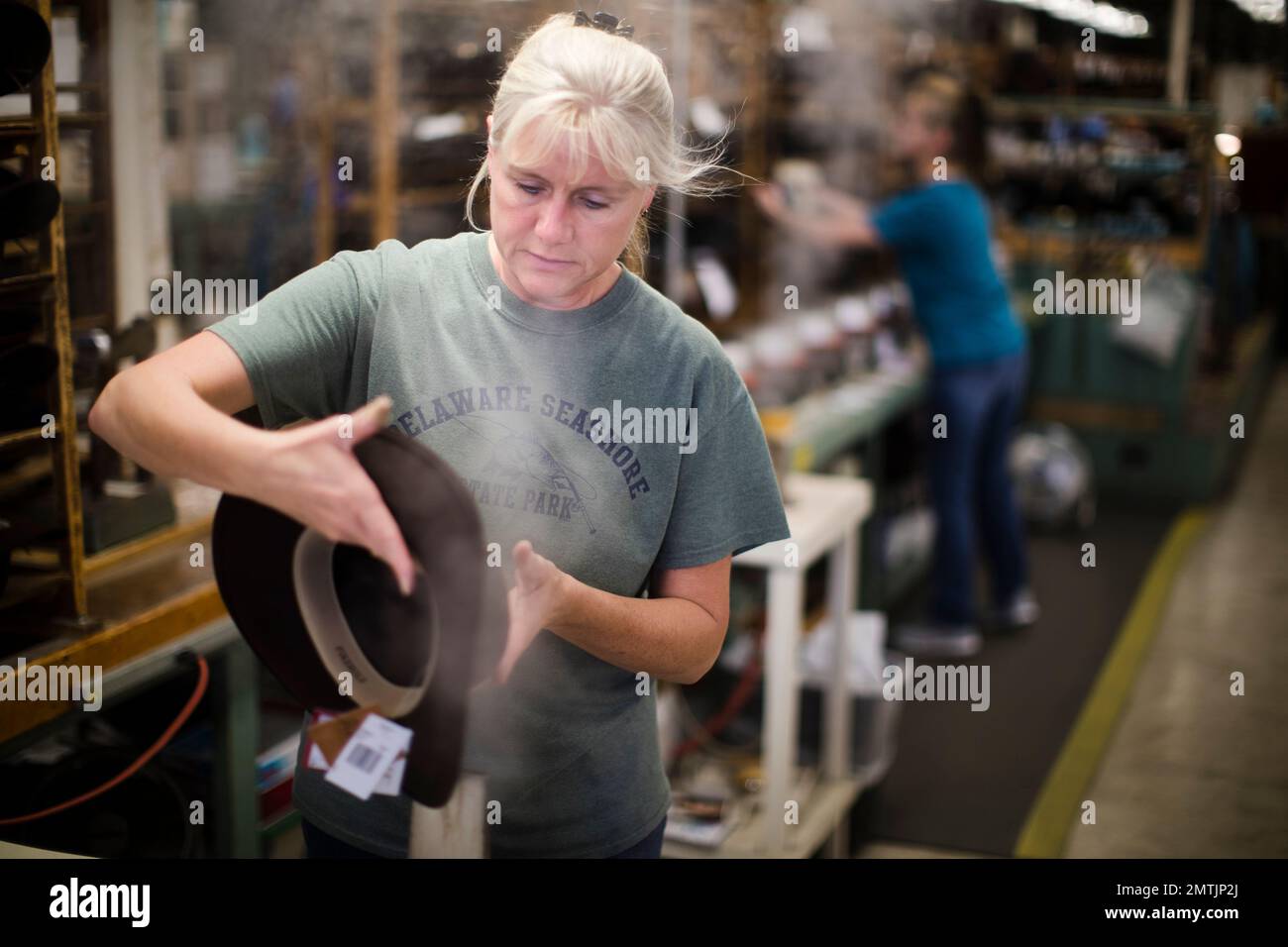 A worker takes part in the manufacturing of hats the Bollman Hat
