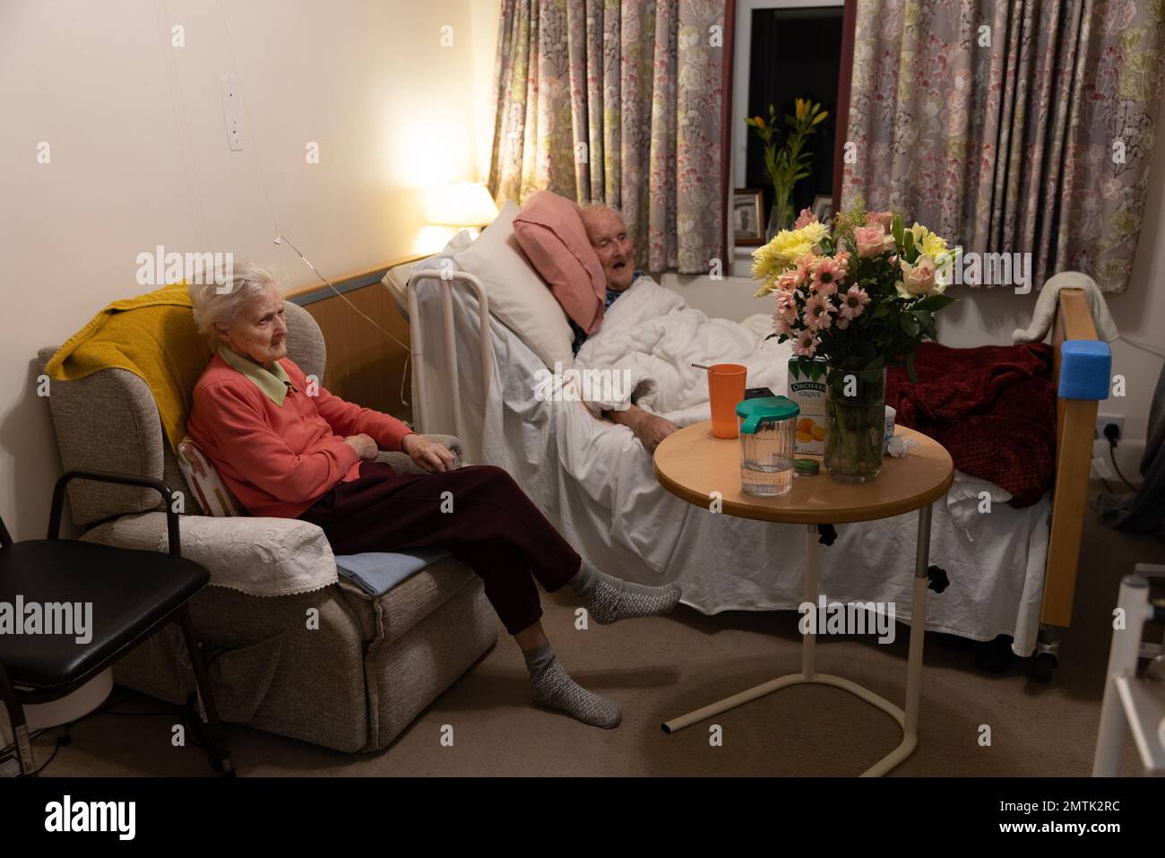 Elderly couple in the eighties together in a residents nursing home bedroom, England, UK Stock Photo