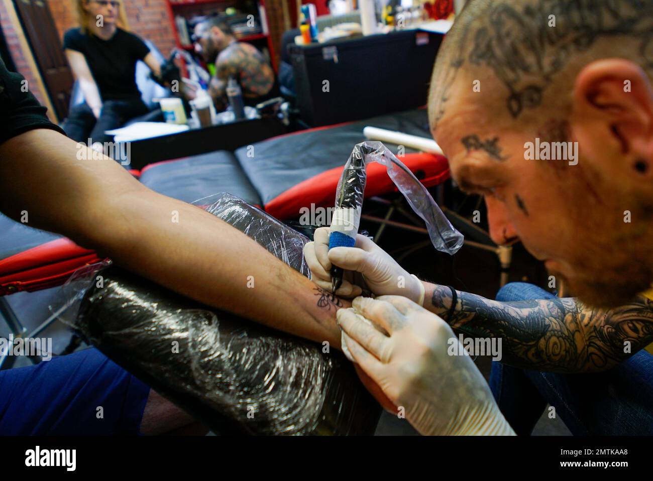 A tattoo artist tattoos a bee on a Mancunian's wrist at his studio in Manchester, Sunday, May 28, 2017. Manchester residents are getting tattoos of bees done in the wake of Monday A tattoo artist tattoos a bee on a Mancunian's wrist at his studio in Manchester, Sunday, May 28, 2017. Manchester residents are getting tattoos of bees done in the wake of Monday