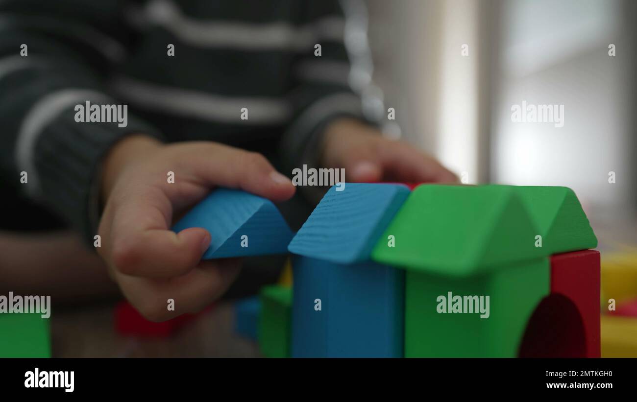 Kid hand plays with colorful blocks. Child playing with building block
