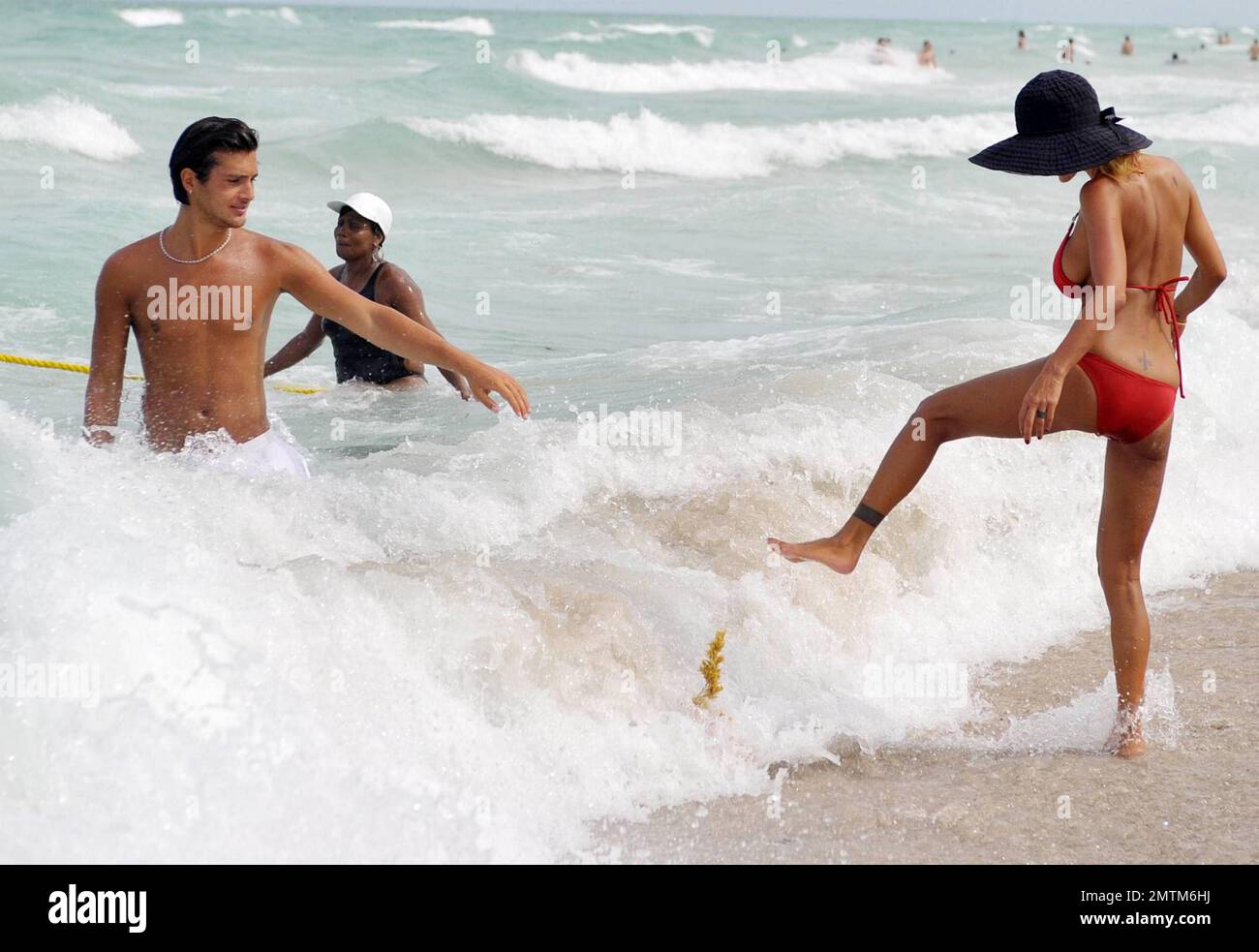 Former Playboy model Shauna Sand enjoys another day at the beach with her  new young tanned boyfriend. Shauna and her new beau played around in the  ocean and later laid in the