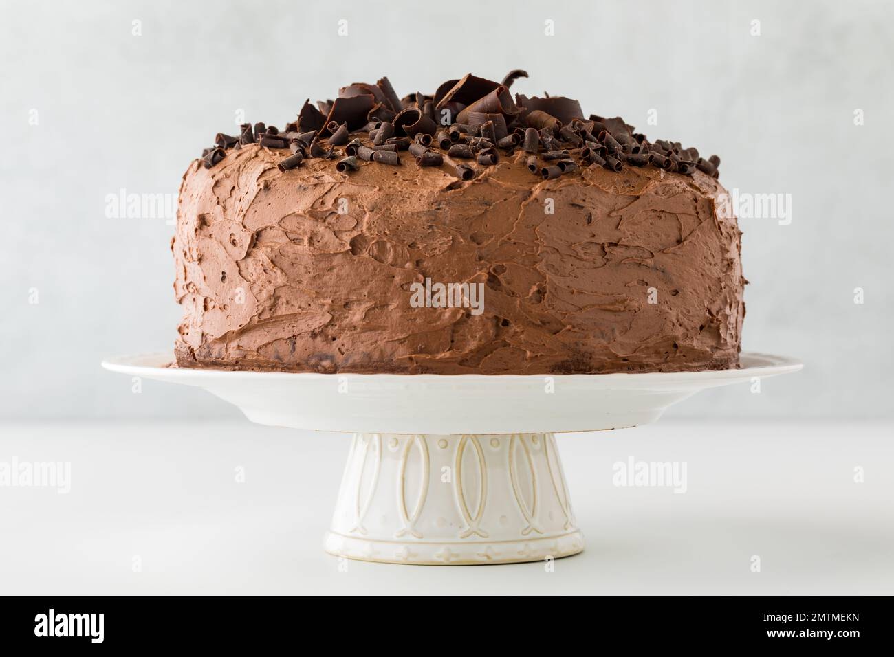 A whole triple layered low sugar chocolate cake on a pedestal stand. Stock Photo