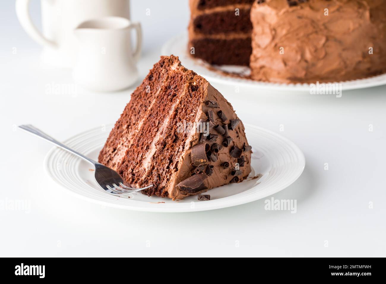 A large slice of triple layered decadent chocolate cake, ready for eating. Stock Photo
