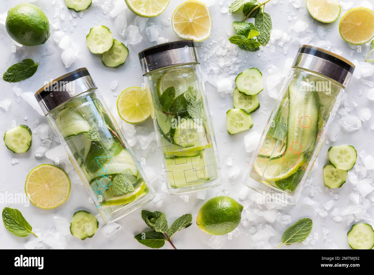 Glass bottles of cucumber water with lime and mint mixed in. Stock Photo