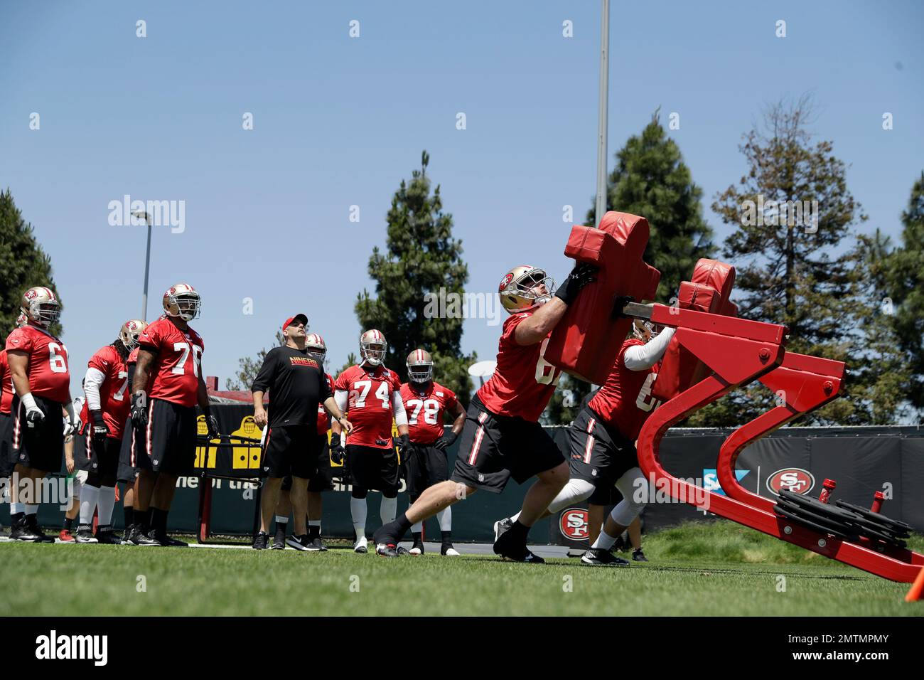 San Francisco 49ers offensive linemen hit the blocking sled during the