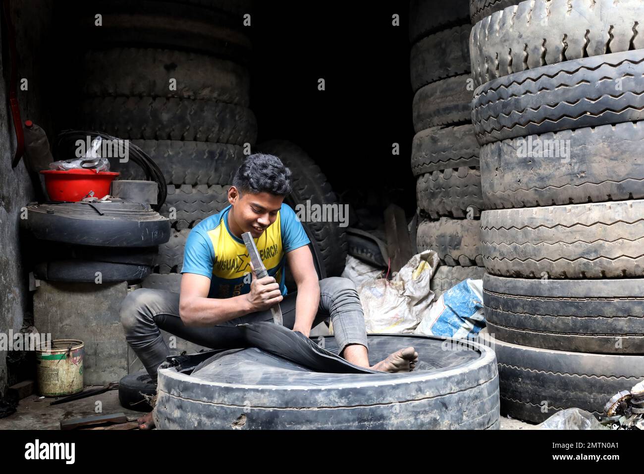 Dhaka, Dhaka, Bangladesh. 1st Feb, 2023. A worker cuts old car tires