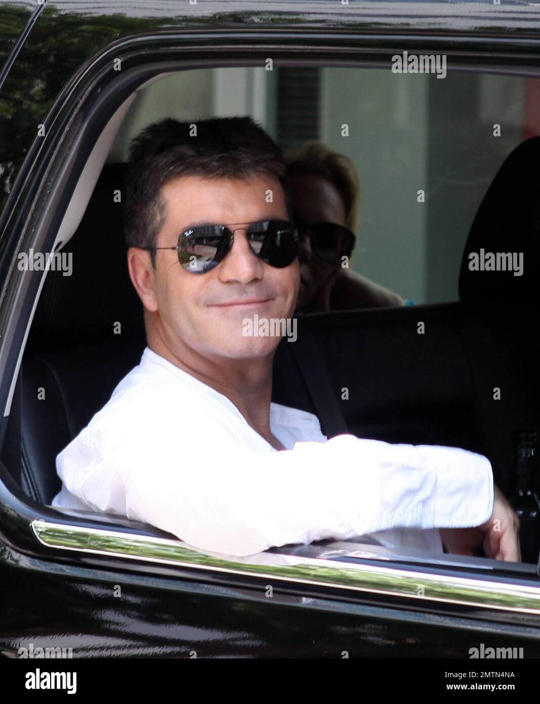 In town for "The X-Factor" auditions, Simon Cowell carries his clothes on  hangers as he leaves his luxury hotel. Once inside the waiting SUV, Cowell  lit up a cigarette and waved before