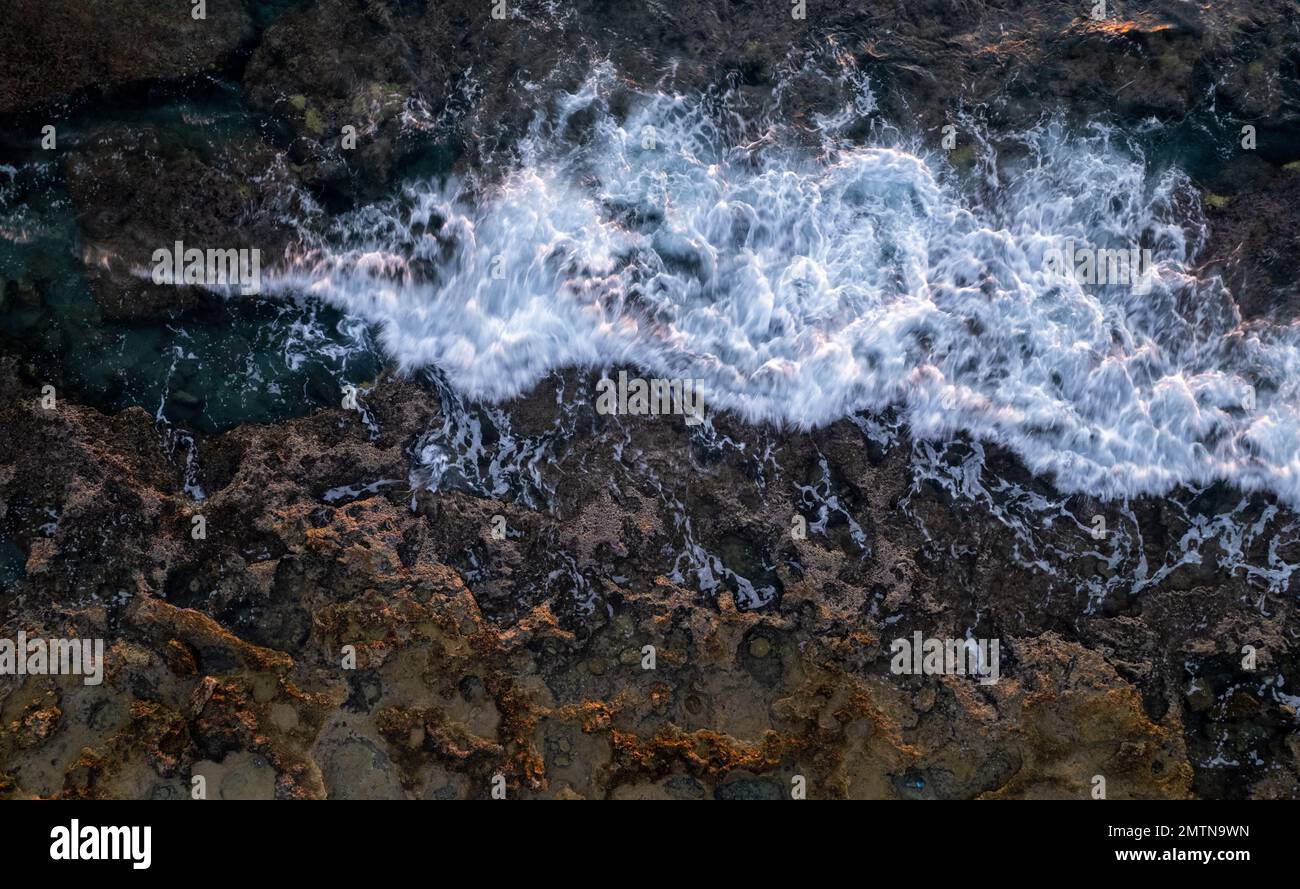 Drone scenery of stormy waves hitting a rocky coast. nature background , dangerous waves Stock Photo