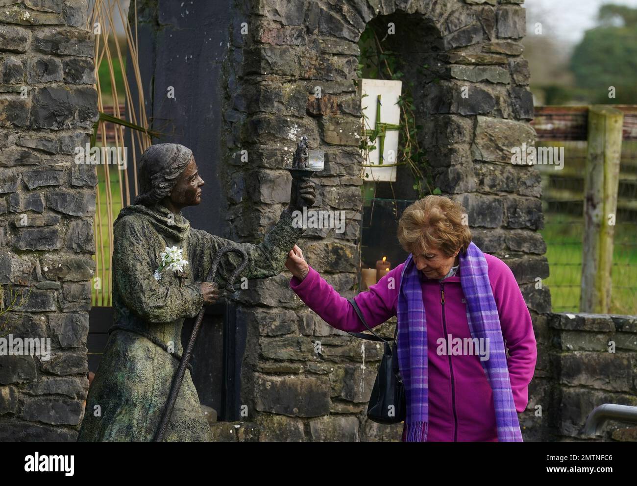 A woman touches a statue of St. Brigid at St Brigid's holy well in Co Kildare. February 1st marks St Brigid's Day which is seen by many in Ireland as the first day of Spring. Picture date: Wednesday February 1, 2023. Stock Photo