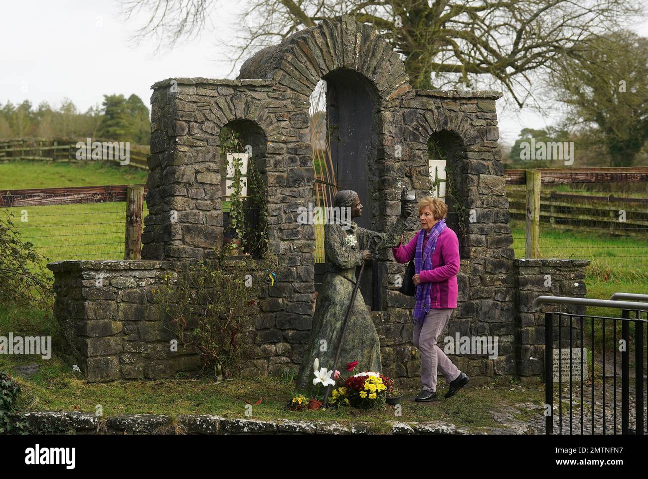 A woman touches a statue of St. Brigid at St Brigid's holy well in Co Kildare. February 1st marks St Brigid's Day which is seen by many in Ireland as the first day of Spring. Picture date: Wednesday February 1, 2023. Stock Photo