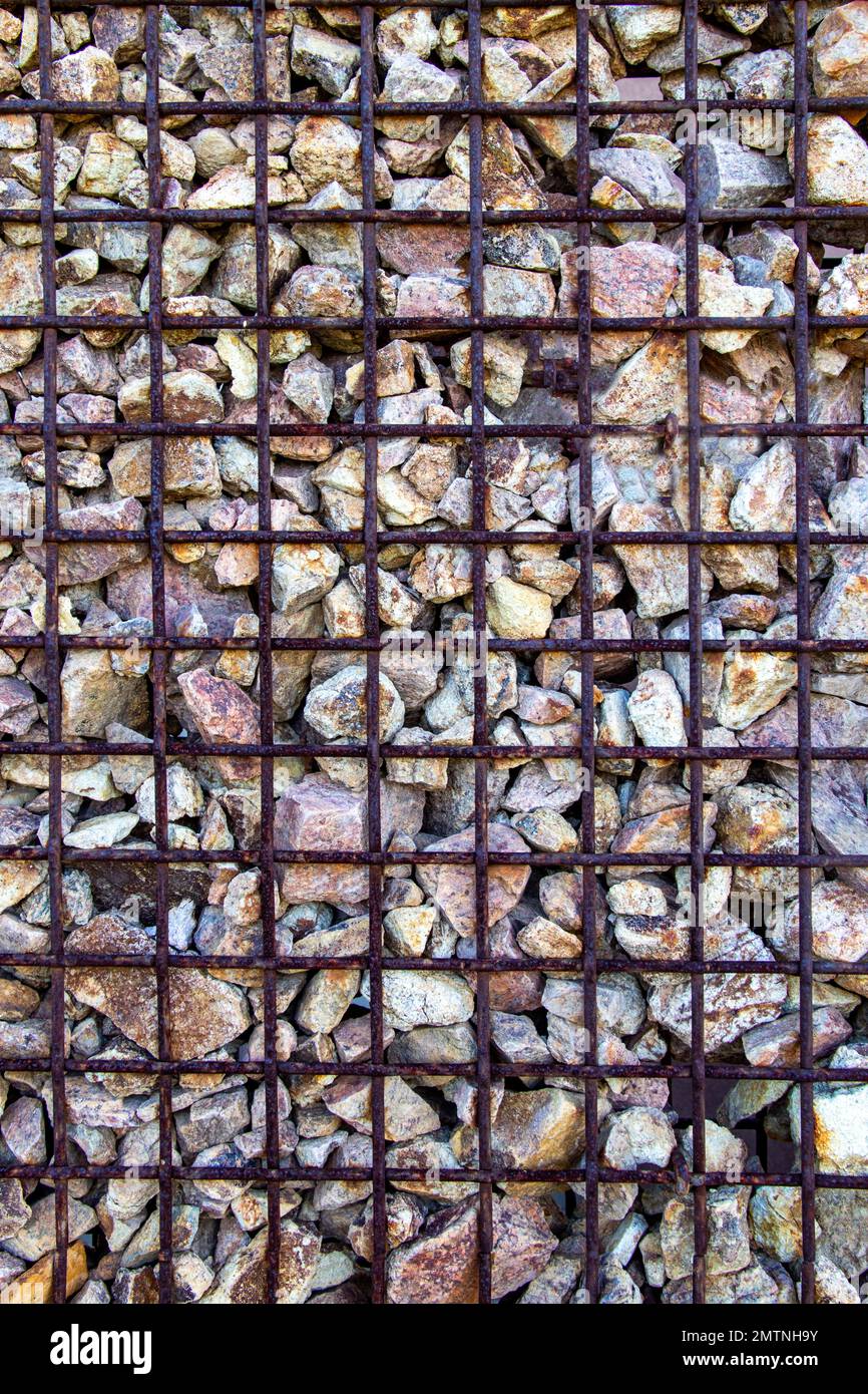 Front view of wire cage basket retaining wall filled with stones for