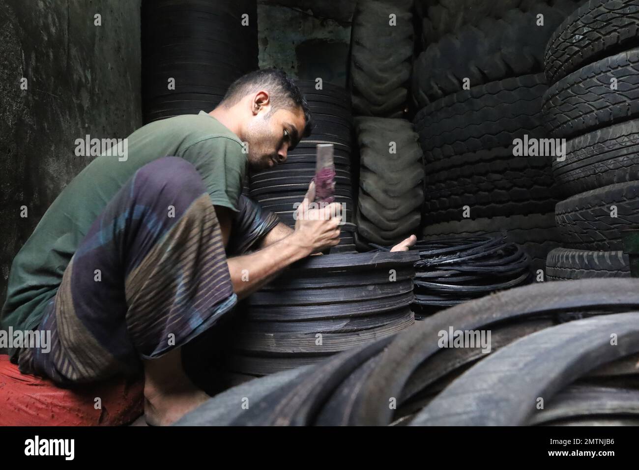 Dhaka, Dhaka, Bangladesh. 1st Feb, 2023. A worker cuts old car tires