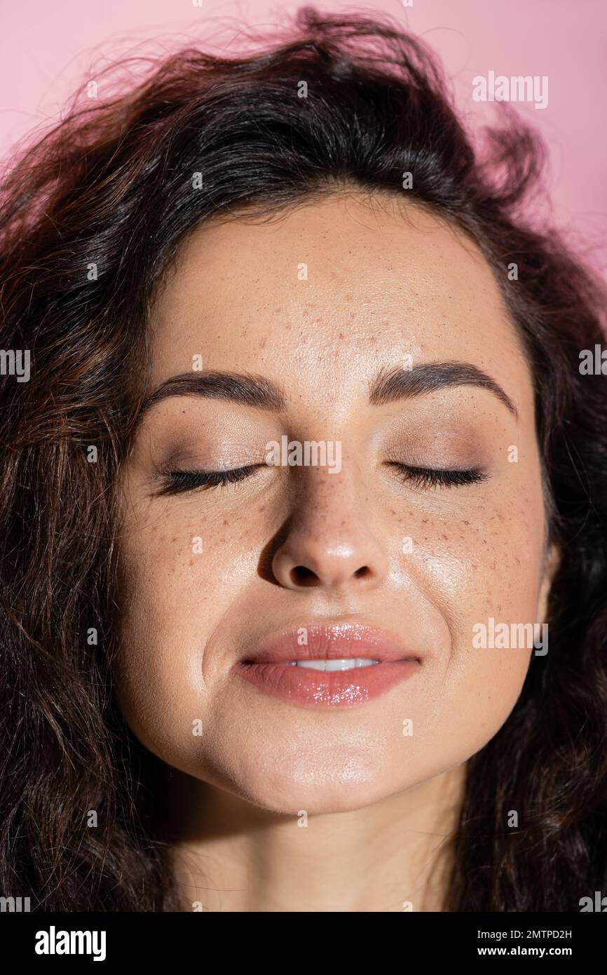 Portrait of smiling freckled woman closed eyes isolated on pink,stock image Stock Photo