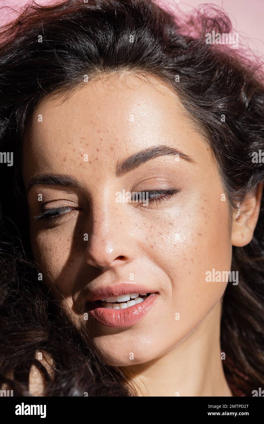 Freckled young woman looking away isolated on pink,stock image Stock Photo