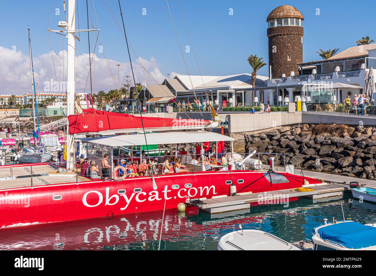 Tourists aboard the Obycat Experience catamaran in the harbour at Caleta de Fuste on the east coast of the Canary Island of Fuerteventura, Spain Stock Photo
