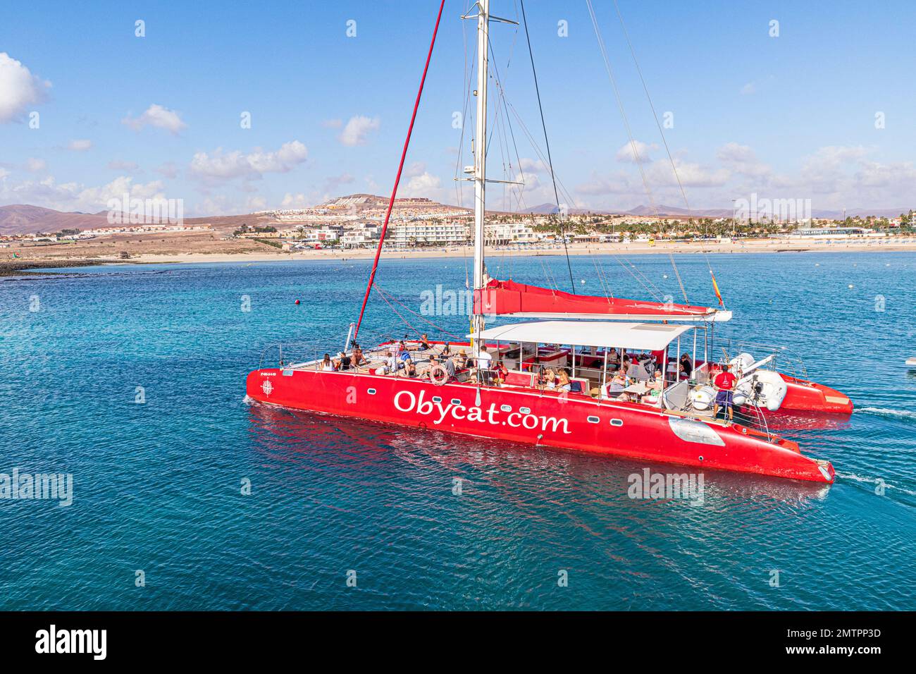 Tourists aboard the Obycat Experience catamaran leaving the harbour at Caleta de Fuste on the east coast of the Canary Island of Fuerteventura, Spain Stock Photo