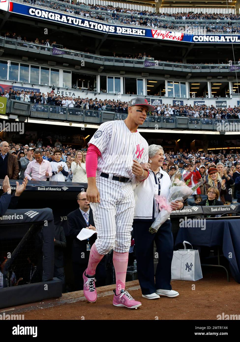 New York Yankees outfielder Aaron Judge escorts Dot Jeter onto