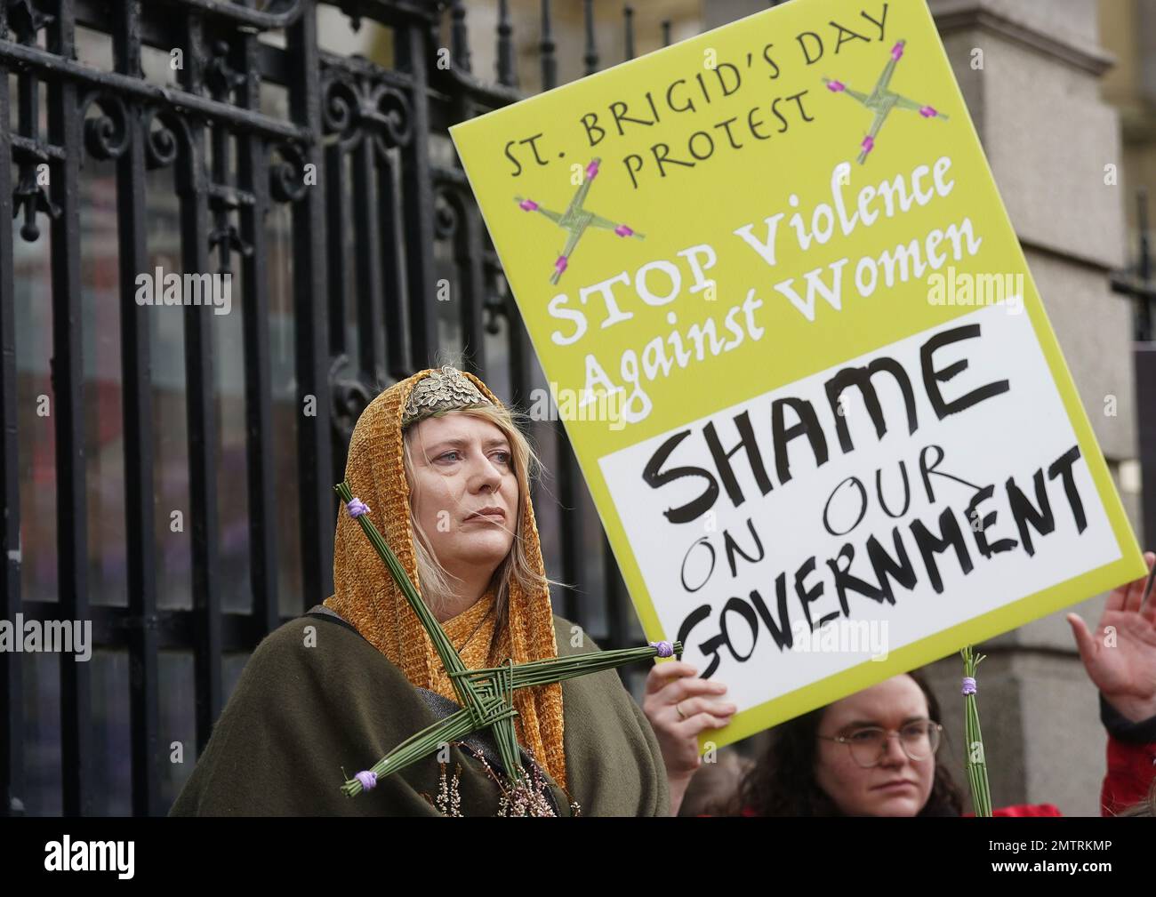 Lisamarie Johnson (left), holding a traditional St. Brigid's Cross made from rushes, attends a St Brigid's Day rally outside Leinster House, Dublin, calling on the Government to take action in addressing violence against women in Ireland. The rally was held to coincide with St Brigid’s Day, with speakers asking that women be protected in the spirit of the Celtic goddess and Christian saint Brigid, who is associated with healing. Picture date: Wednesday February 1, 2023. Stock Photo