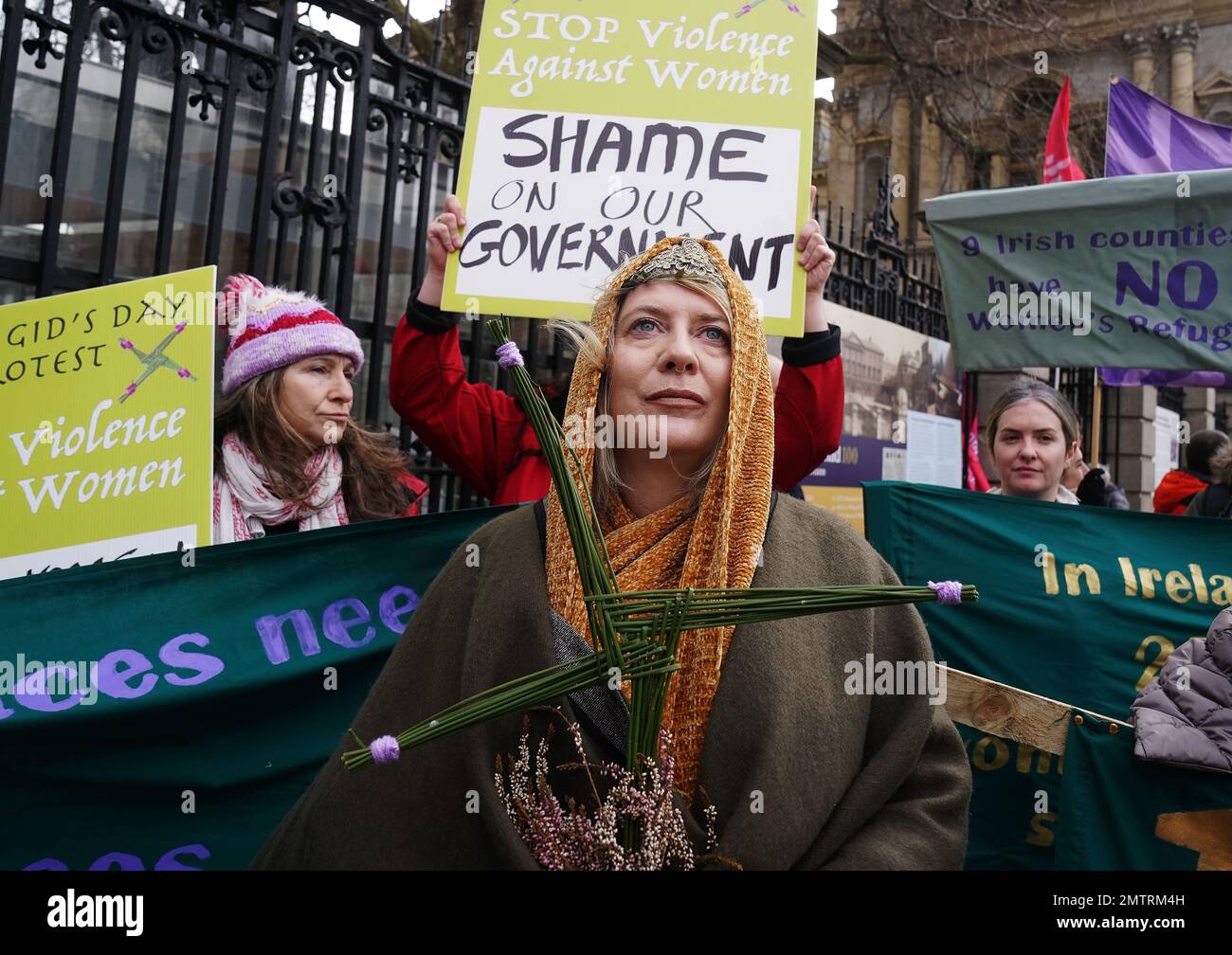 Lisamarie Johnson (centre), holding a traditional St. Brigid's Cross made from rushes, attends a St Brigid's Day rally outside Leinster House, Dublin, calling on the Government to take action in addressing violence against women in Ireland. The rally was held to coincide with St Brigid’s Day, with speakers asking that women be protected in the spirit of the Celtic goddess and Christian saint Brigid, who is associated with healing. Picture date: Wednesday February 1, 2023. Stock Photo