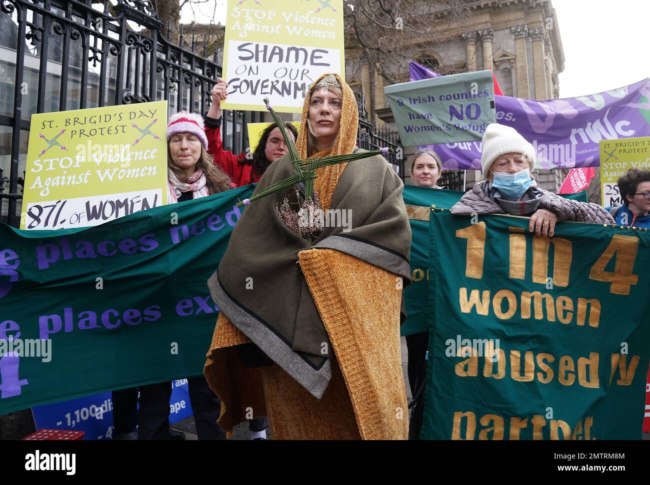 Lisamarie Johnson (centre), holding a traditional St. Brigid's Cross made from rushes, attends a St Brigid's Day rally outside Leinster House, Dublin, calling on the Government to take action in addressing violence against women in Ireland. The rally was held to coincide with St Brigid’s Day, with speakers asking that women be protected in the spirit of the Celtic goddess and Christian saint Brigid, who is associated with healing. Picture date: Wednesday February 1, 2023. Stock Photo