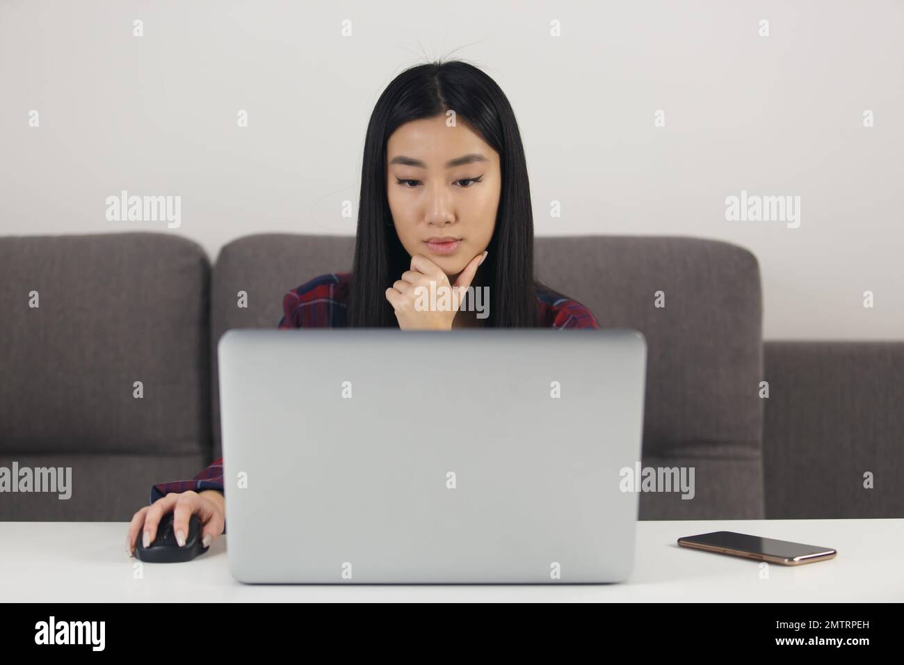 Pensive Vietnamese female studying online. Portrait of asian POC girl