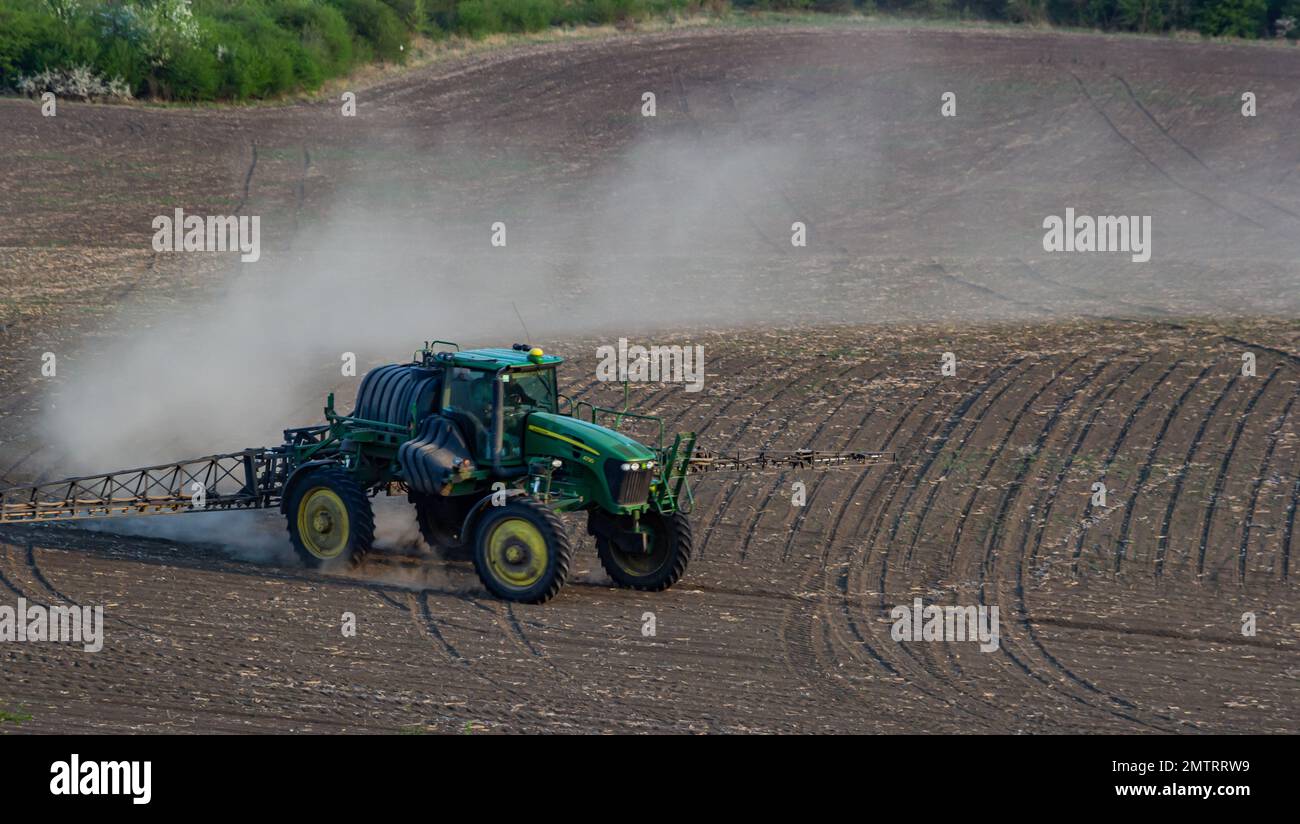 Tractor spray fertilizer spraying pesticides on green field