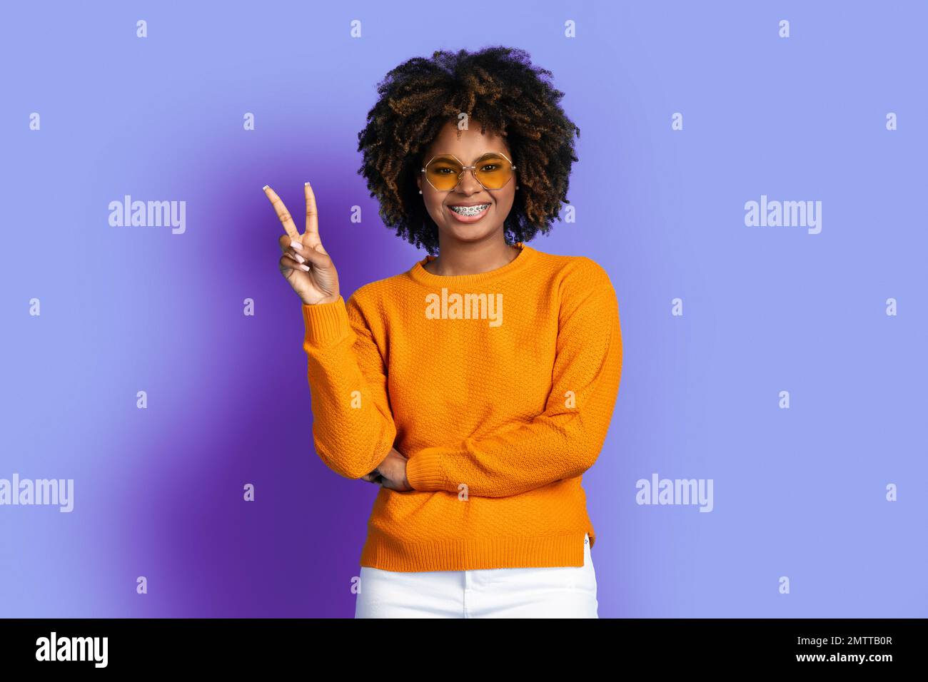 Cool stylish young black woman posing on purple Stock Photo