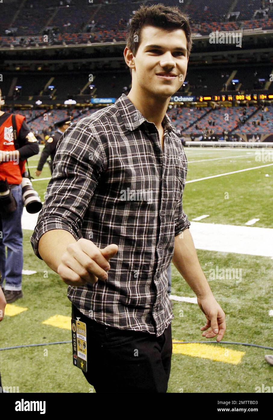 Taylor Lautner signs an autograph while on the ootball ield at Louisiana Superdome ater the St. Louis Rams versus New Orleans Saints game.  The 'Twilight' star walked with a security entourage and met with some people on the ield.  Also at the game was actress Miley Cyrus who is in town to shoot her new movie 'So Undercover'.  A ew months back rumors circulated suggesting the teens might work on a ilm together. New Orleans, LA. 12/12/10. Stock Photo