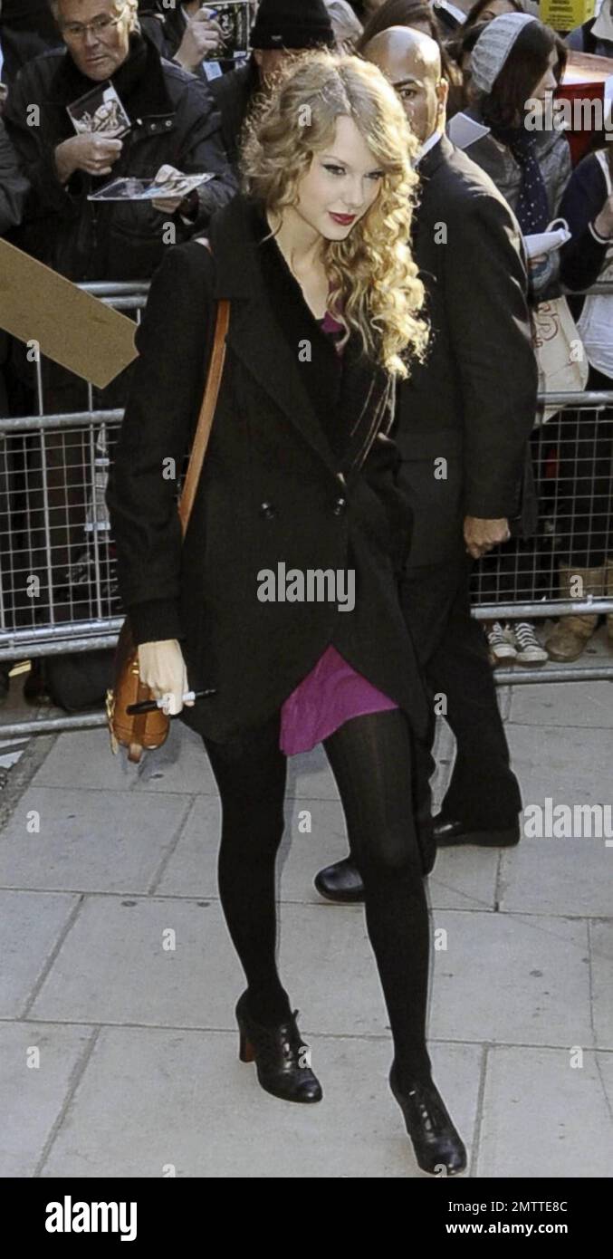 Country music superstar Taylor Swift draws a huge crowd outside the BBC during appearances on Radio 1 and Radio 2. After her performance on Radio 2's Simon Mayo Drivetime, she took a moment to pose for photos with some young fans while headed to her car accompanied by security. London, UK. 10/20/10.   . Stock Photo