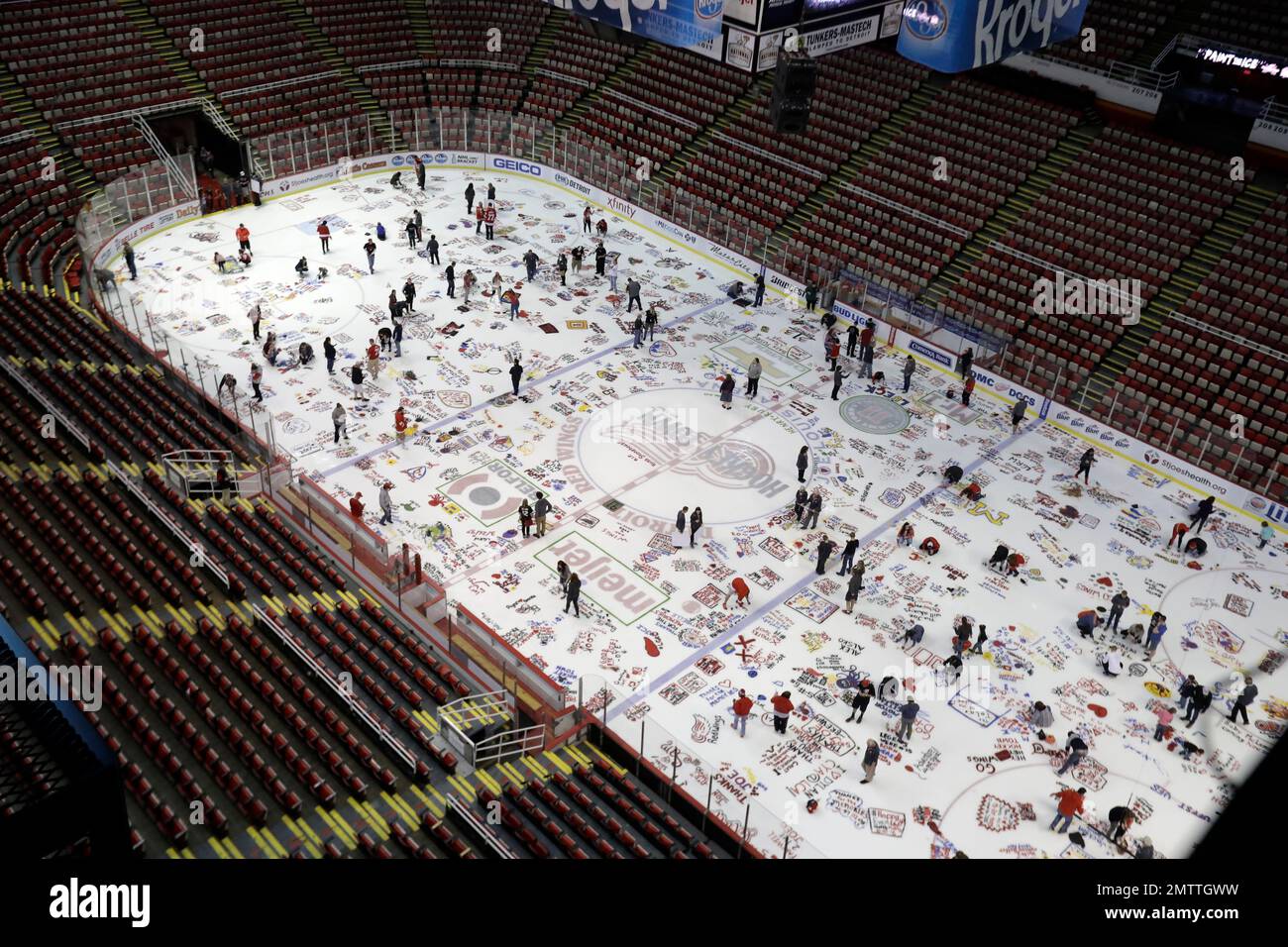 Detroit Red Wings fans paint tributes on the ice at the Joe Louis