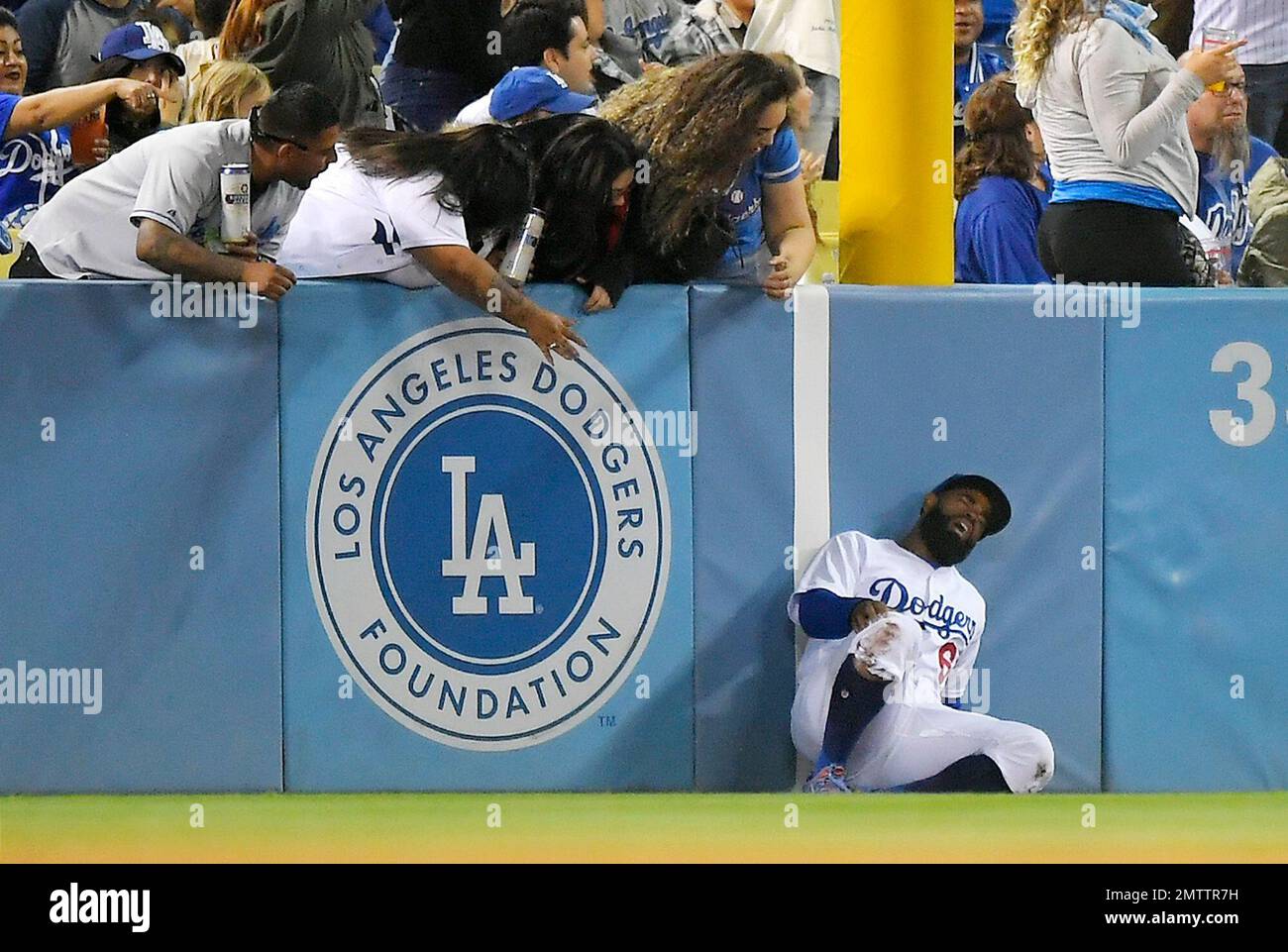 Los Angeles Dodgers left fielder Andrew Toles writhes after