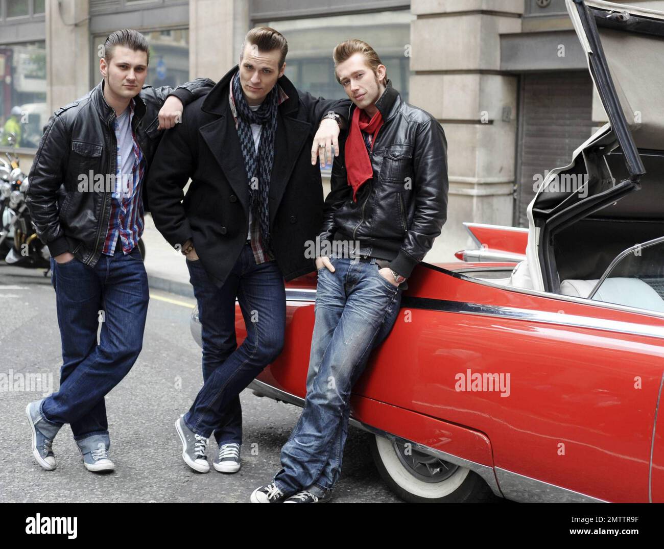 Berlin-bred rockabilly musicians The Baseballs pose in their classic red convertible Cadillac outside the BBC Radio 2 studios promoting their new album Strike. The trio, Sam, Digger and Basti, are known