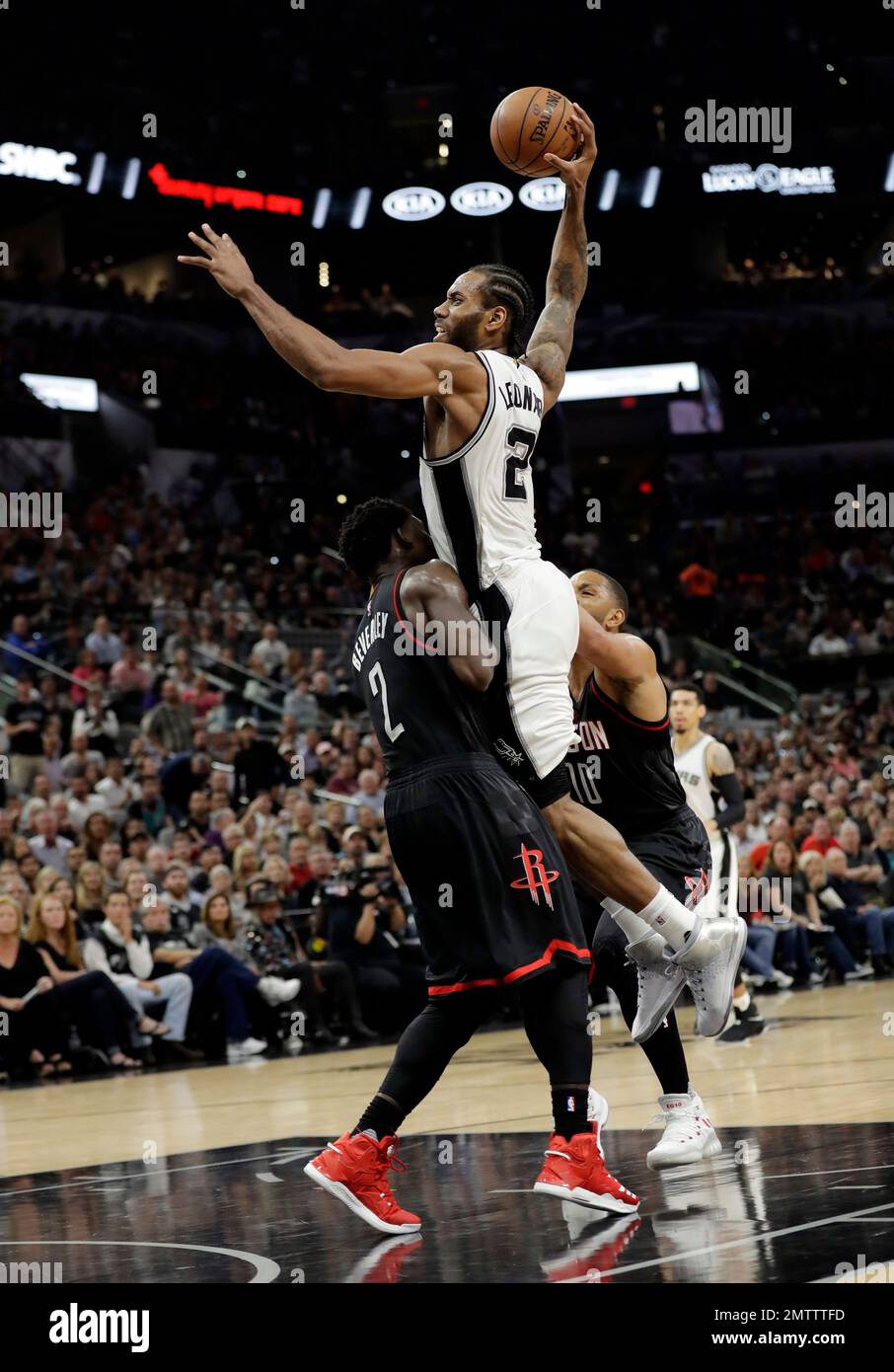 San Antonio Spurs forward Kawhi Leonard, top, is fouled by