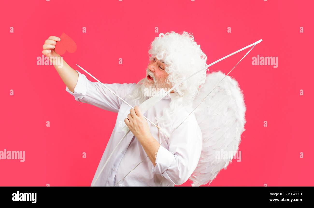 Cupid in valentines day with red paper heart. Male angel with bow and arrow. Arrows of love. Stock Photo