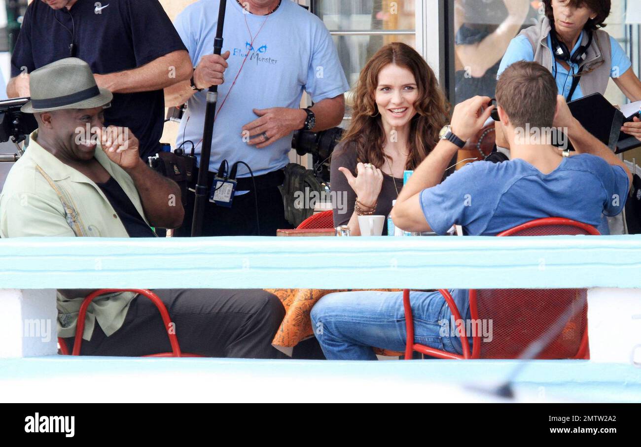 Michael Clarke Duncan, Saffron Burrows and Geoff Stults film scenes on location for the TV series 'The Finder'.  While on set Michael Clarke Duncan, who got his make up touched up by a makeup artist, Geoff Stults and Saffron Burrows had a good laugh in between takes.  Saffron Burrows, who took direction and appeared to be playing the part of a waitress, looked great in aviator sunglasses, a tight brown top and flare jeans. Miami, FL. 02/24/11. Stock Photo