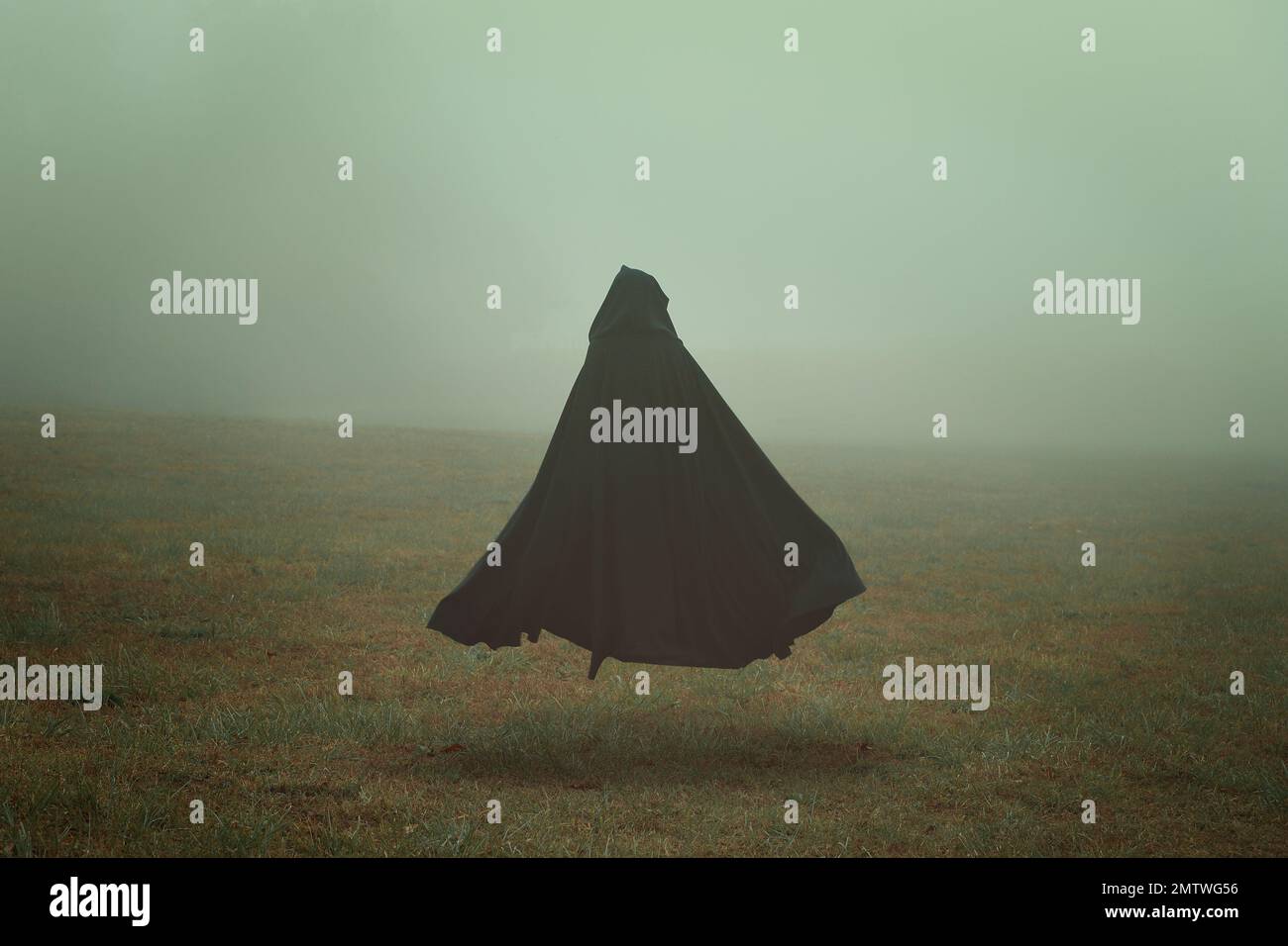 Black cloak in a desolate field Stock Photo