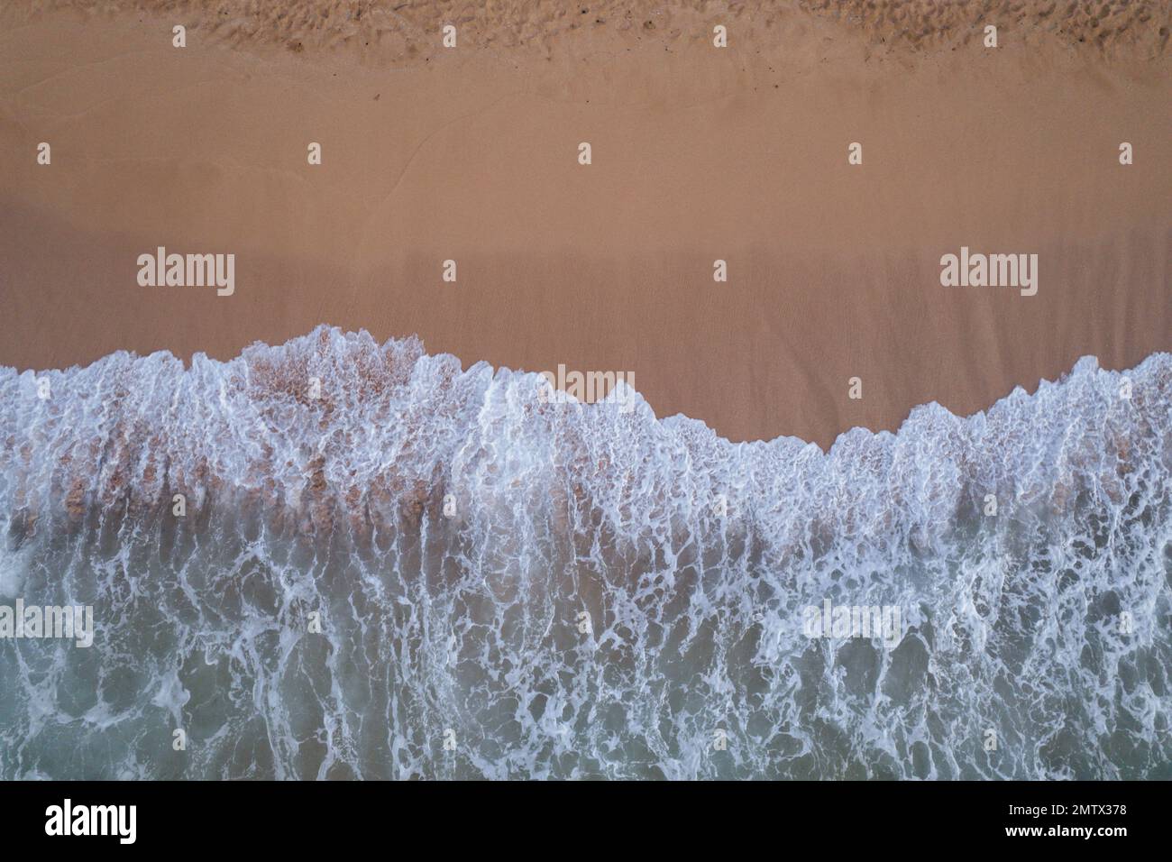 Top Down View of Waves Crashing on Beach Stock Photo