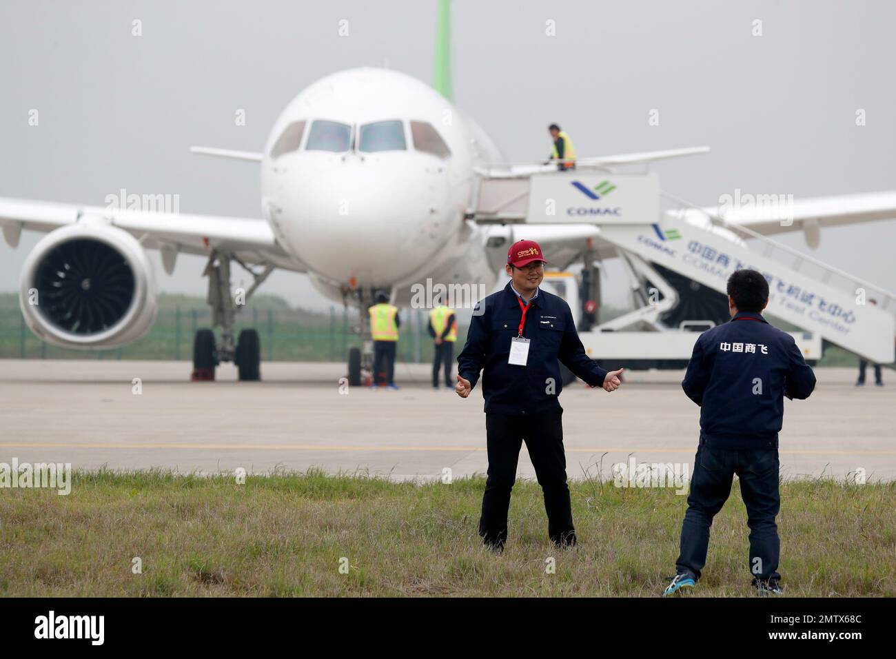 An attendee poses for a photo in front of a Chinese C919 passenger jet ...