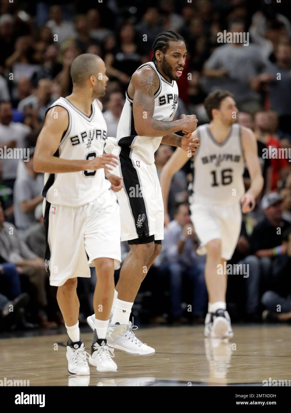 San Antonio Spurs' Kawhi Leonard, center, celebrates a basket as Tony  Parker, left, of France and Pau Gasol (16) of Spain move up court during  the first half of Game 2 in