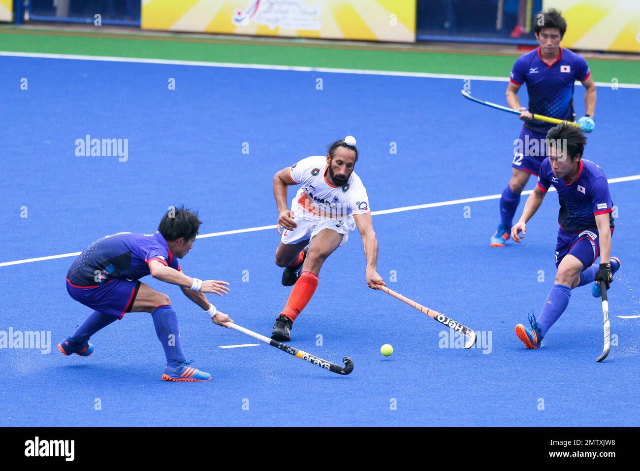 India's Sardar Singh, second from left, keeps the ball off Japan's ...