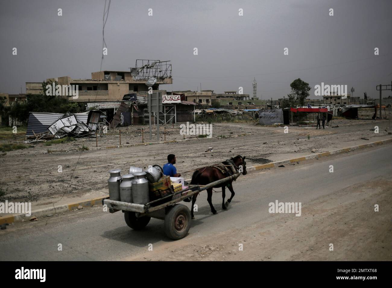 A food salesman rides a cart inside western Mosul on Tuesday, May 2