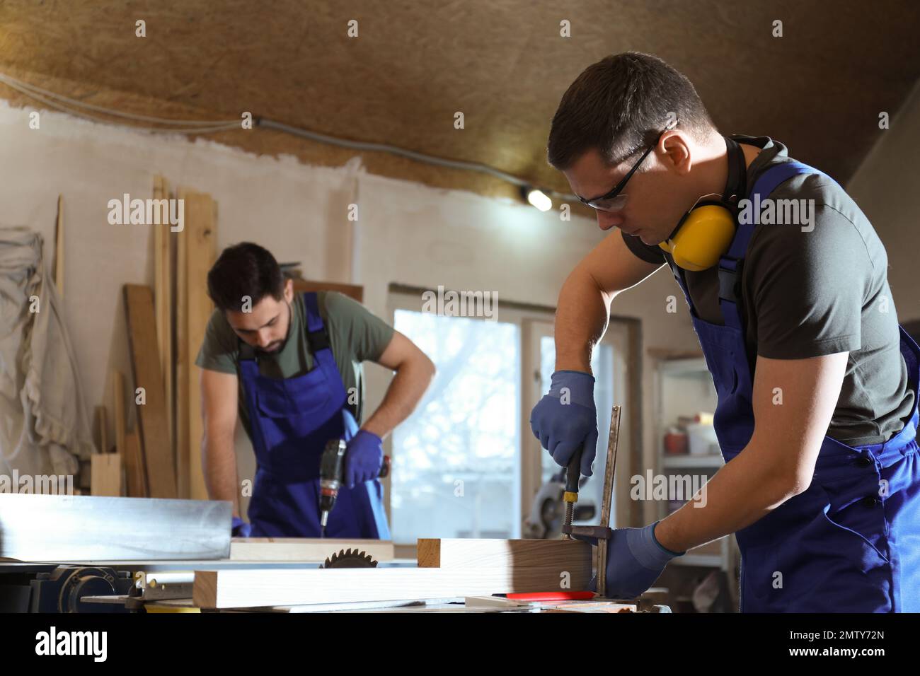 Professional carpenters working with wood in shop Stock Photo