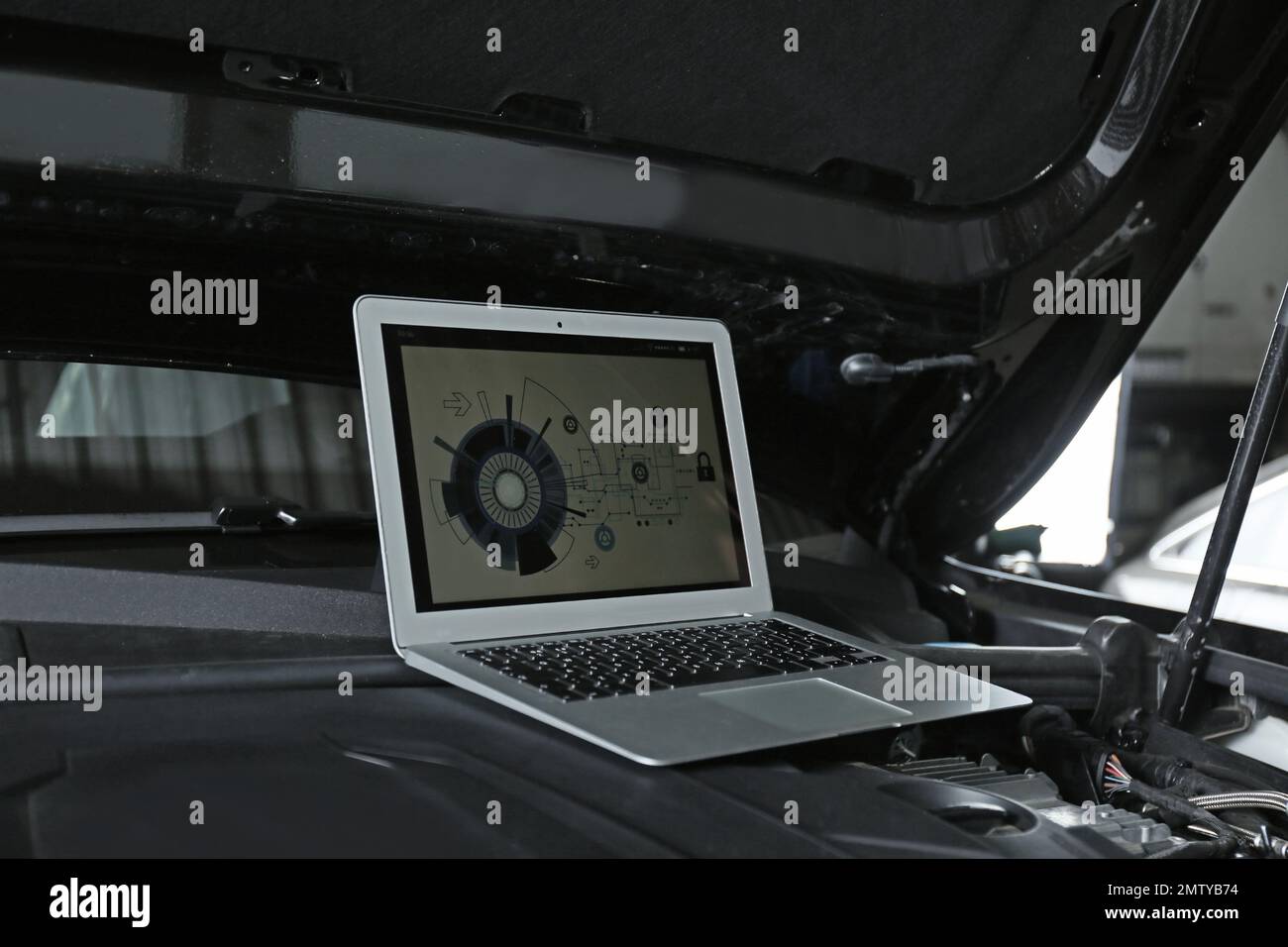 Laptop with diagram on auto engine. Modern car diagnostic Stock Photo