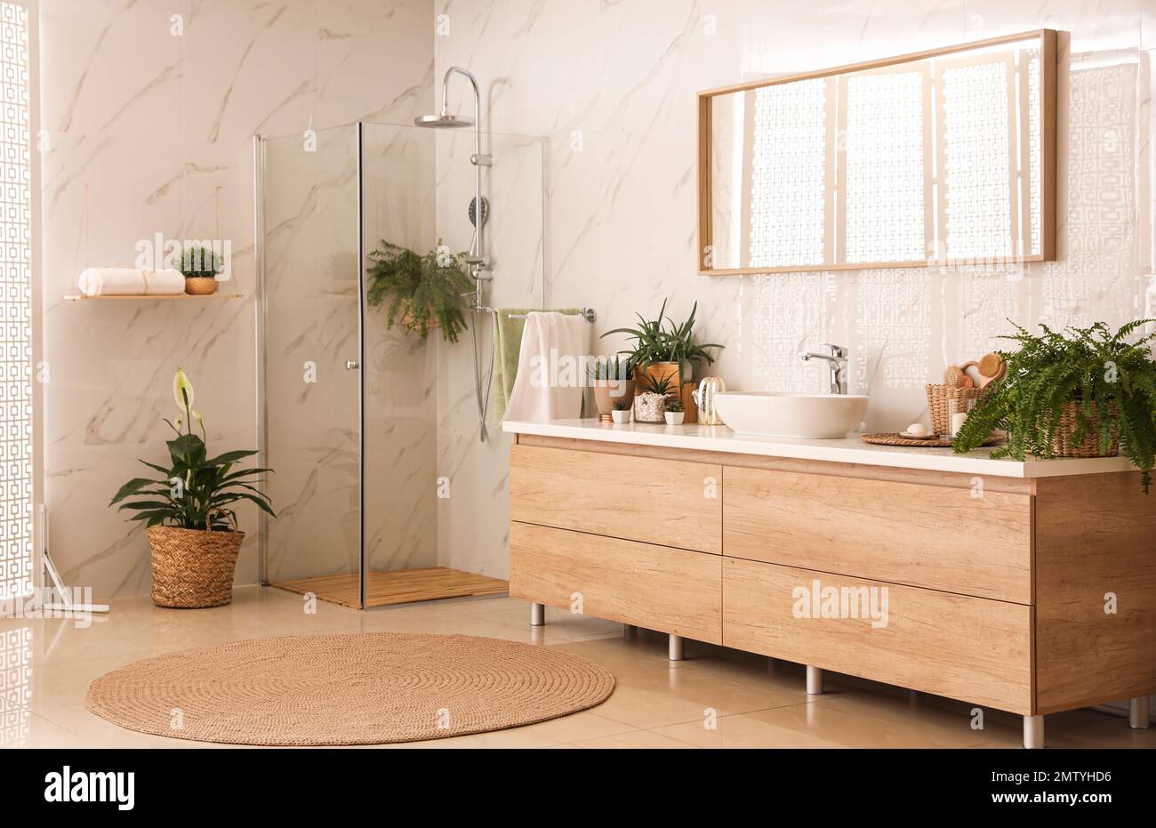 Stylish bathroom interior with countertop, shower stall and houseplants