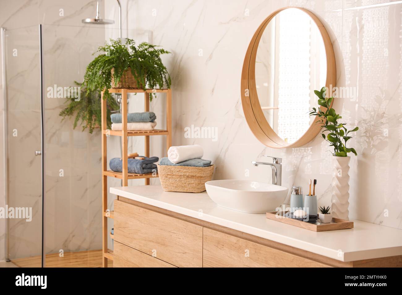 Stylish bathroom interior with countertop, shower stall and houseplants