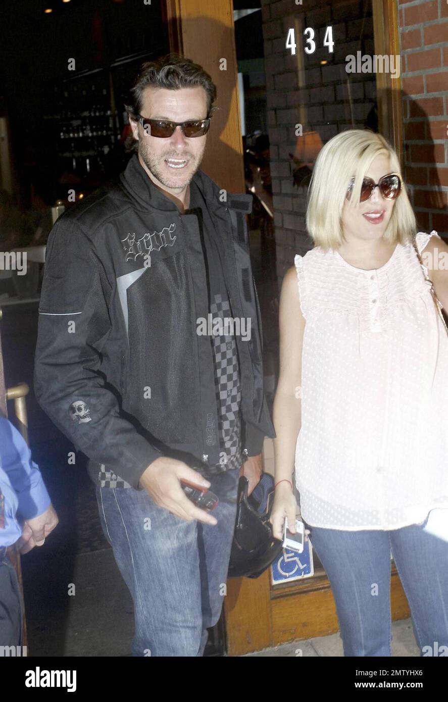 Tori Spelling and husband Dean McDermott have some fun and pull out their cameras and film paparazzi as they leave La Scala in Beverly Hills. Dean also poses for a photo with photogs before he and Tori kiss goodbye. She gets in her SUV while hel hops on his red Ducati motorcycle and rides away. Los Angeles, CA. 8/21/08. Stock Photo