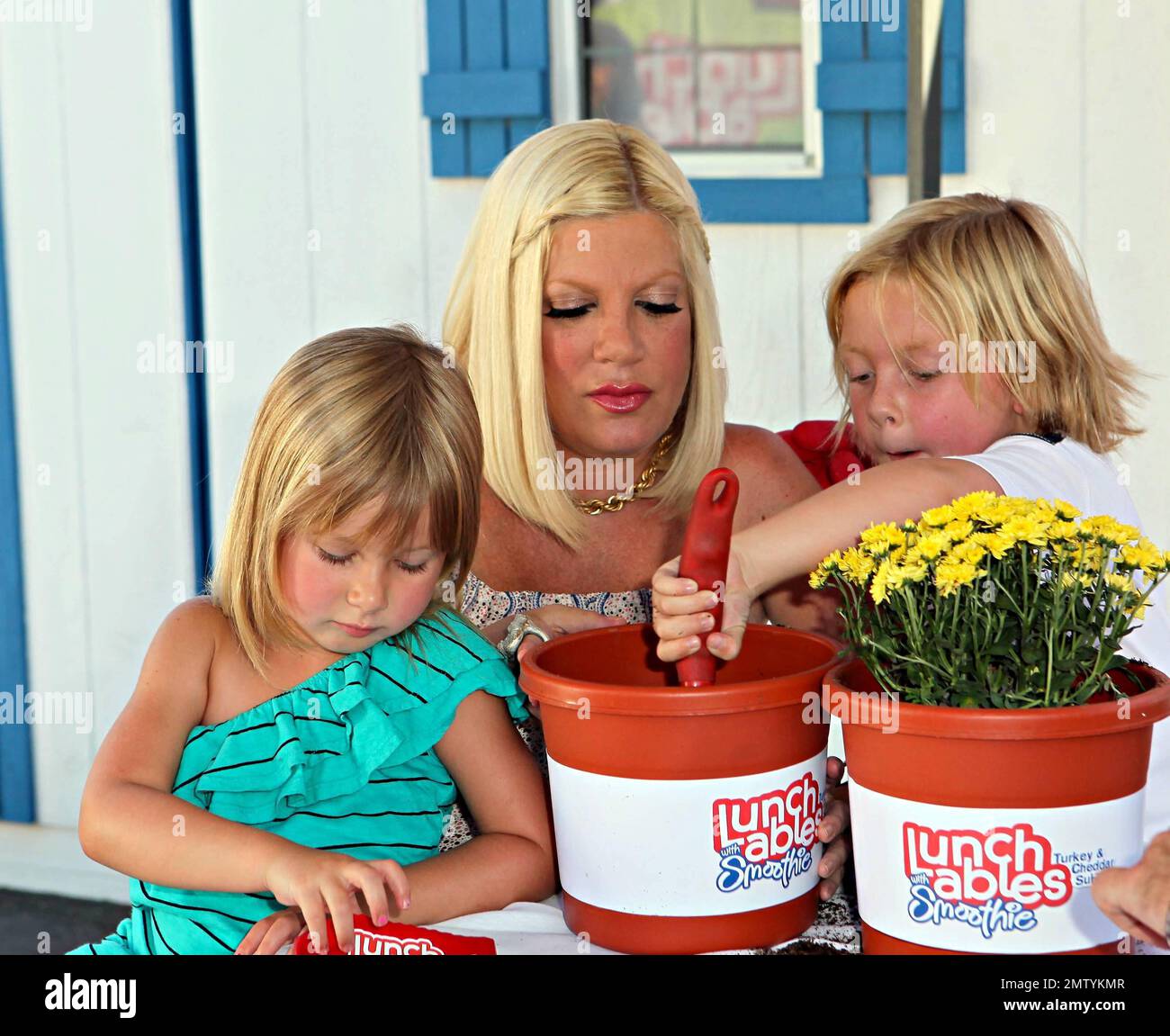 Tori Spelling plants flowers with her children Liam and Stella as(00)