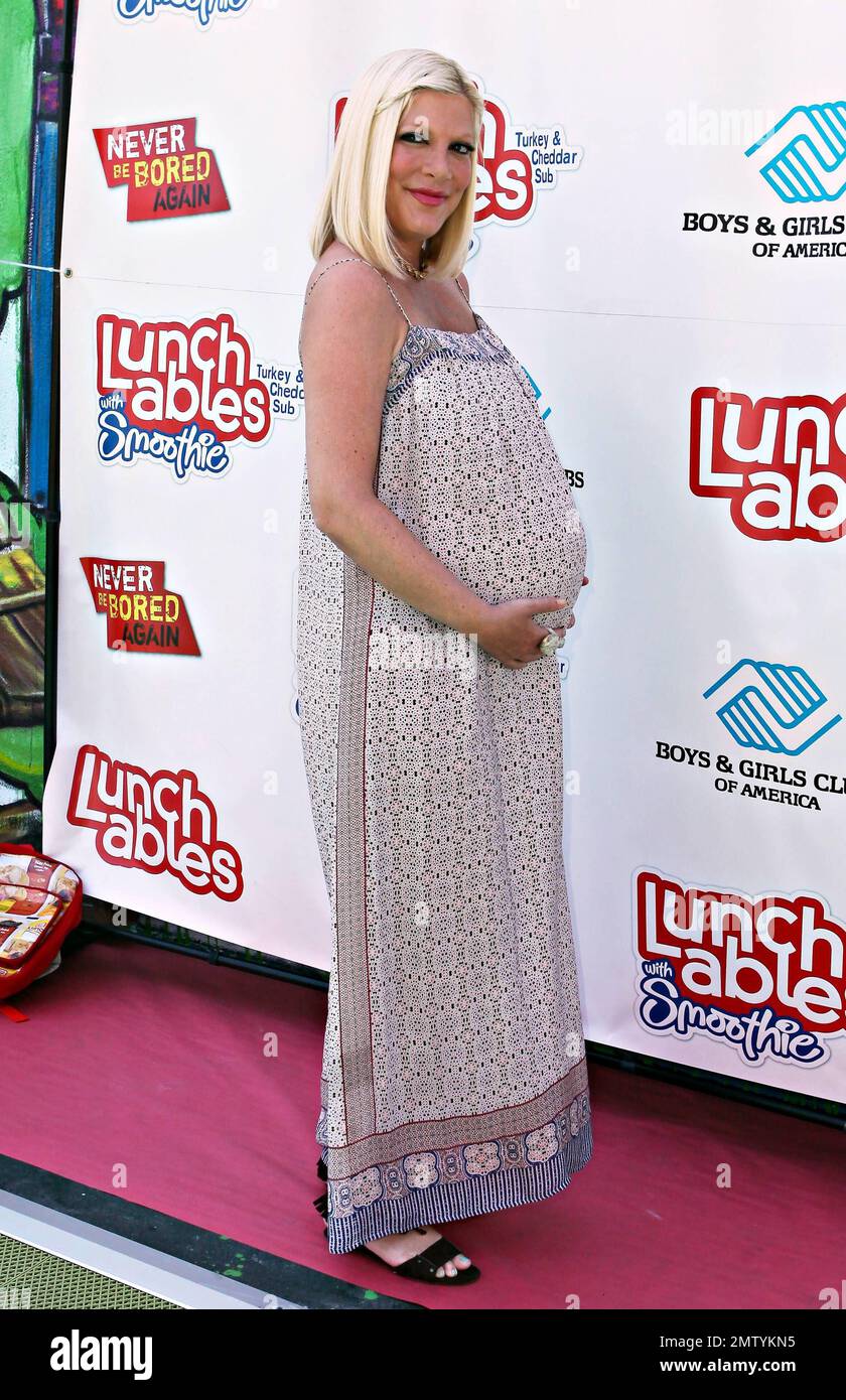 Pregnant Tori Spelling shows off her baby bump as she arrives with son